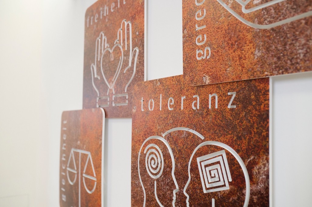 Metallische Wandplaketten mit den AWO-Werten Freiheit, Gleichheit, Gerechtigkeit und Toleranz