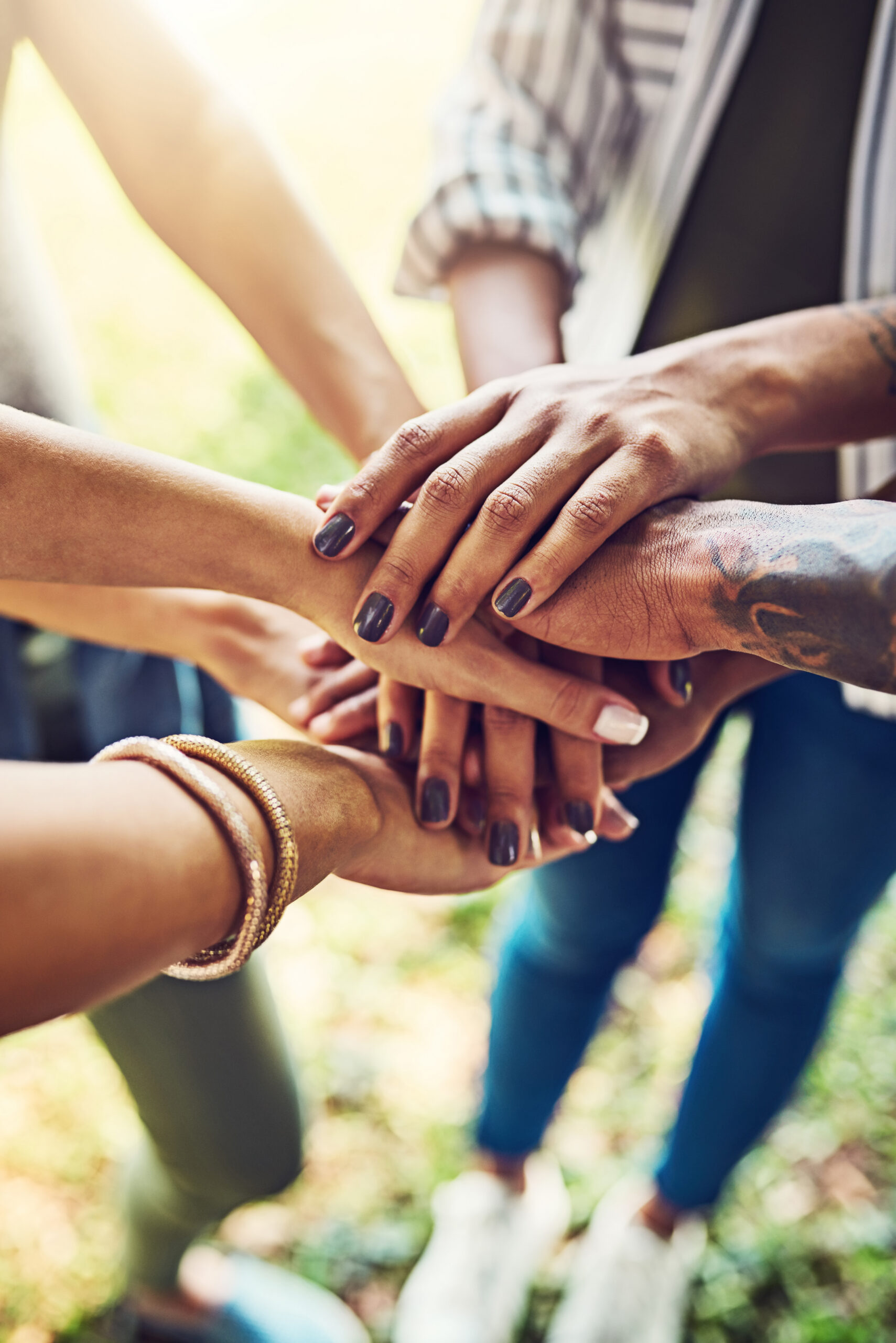 Hands, together and stack for team building with people outdoor, support and solidarity in nature. Community, mission and partnership, trust and commitment with loyalty, group huddle and agreement